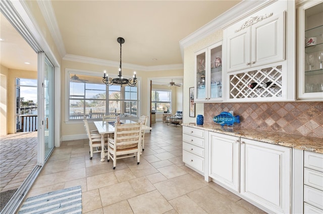 4431 Gardner Dr, Port Charlotte, FL 33952 - dining space with a chandelier, crown molding, a dry bar, ceiling fan, and light tile patterned flooring
