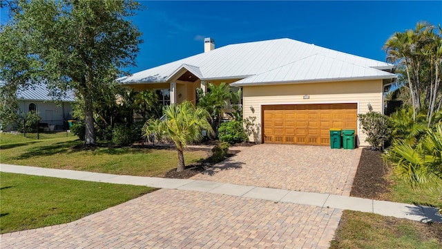 4431 Gardner Dr, Port Charlotte, FL 33952 - single story home with a garage, a front lawn, a chimney, decorative driveway, and a metal roof