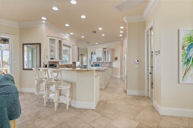 4431 Gardner Dr, Port Charlotte, FL 33952 - kitchen featuring crown molding, a peninsula, backsplash, glass insert cabinets, and recessed lighting