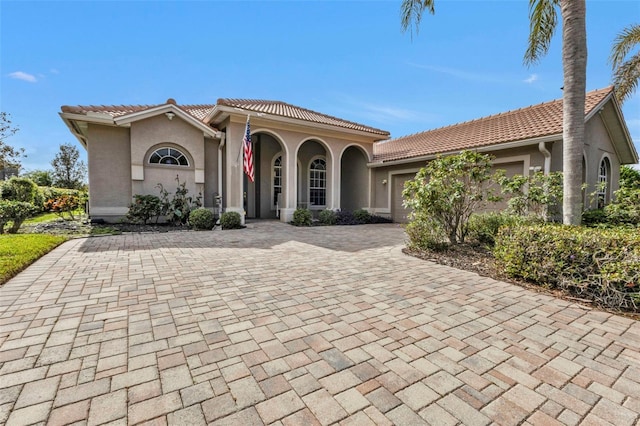 mediterranean / spanish-style house featuring covered porch and a garage