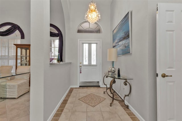 tiled foyer entrance featuring an inviting chandelier