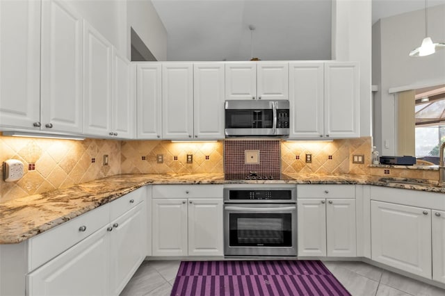 kitchen with white cabinets, appliances with stainless steel finishes, pendant lighting, and sink