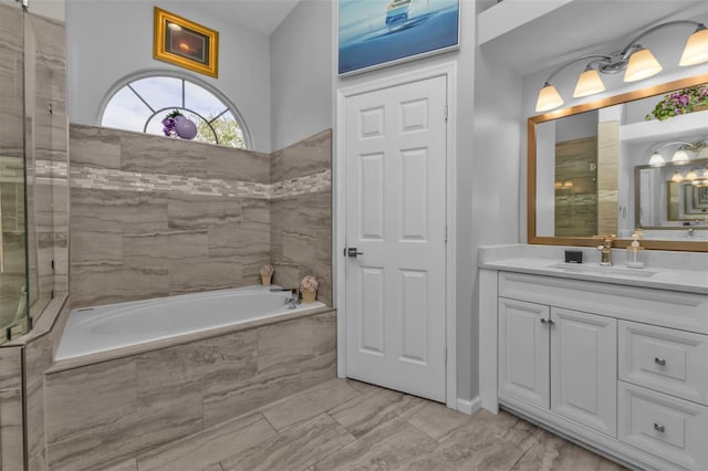 bathroom with vanity and tiled bath