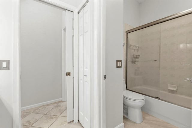 bathroom featuring tile patterned floors, enclosed tub / shower combo, and toilet