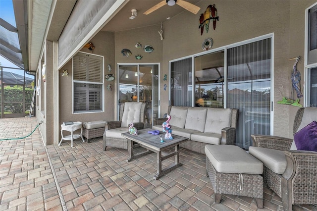 view of patio with glass enclosure, an outdoor living space, and ceiling fan