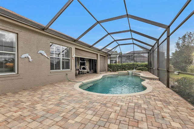 view of swimming pool featuring a hot tub, a patio area, and a lanai