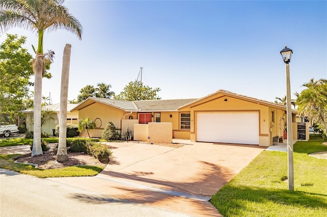 ranch-style house featuring a garage and a front lawn