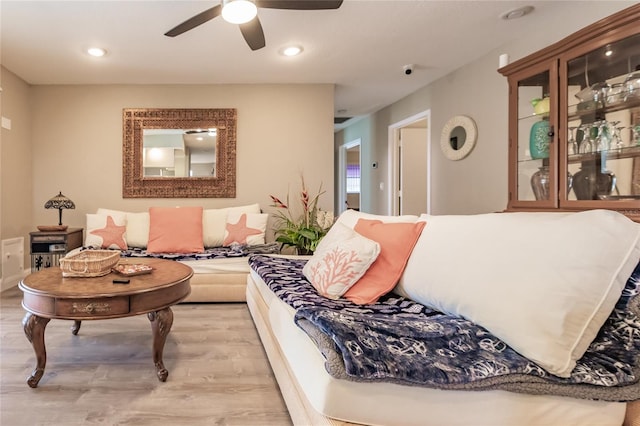 living room featuring ceiling fan and light hardwood / wood-style floors