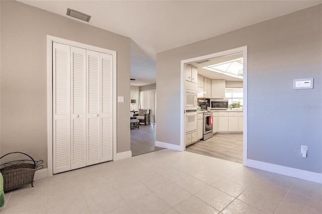 hall featuring light tile patterned floors