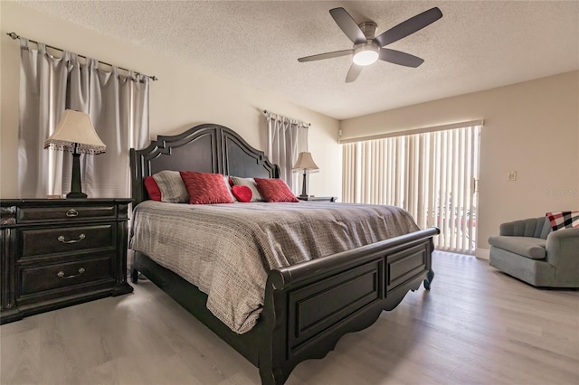 bedroom with ceiling fan, light hardwood / wood-style flooring, and a textured ceiling