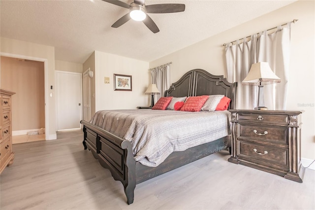 bedroom featuring a textured ceiling, light hardwood / wood-style flooring, and ceiling fan