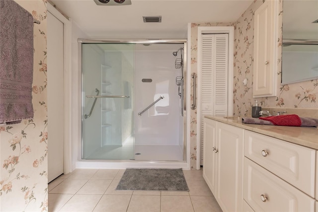 bathroom with tile patterned flooring, vanity, and walk in shower