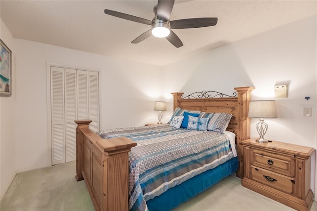 bedroom featuring ceiling fan, light colored carpet, and a closet