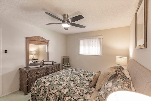 carpeted bedroom with ceiling fan and a textured ceiling