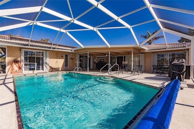 view of swimming pool with glass enclosure and a patio