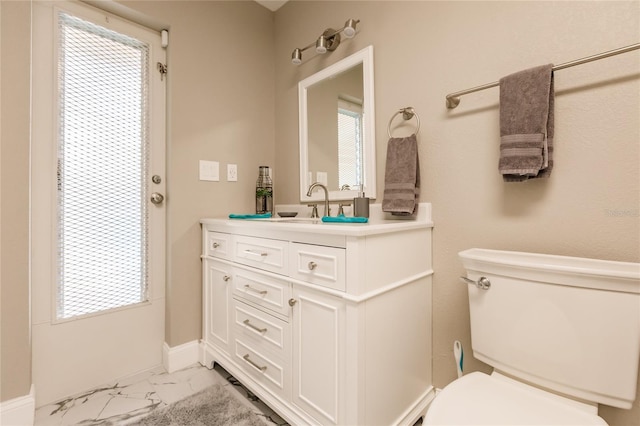 bathroom featuring vanity, toilet, and plenty of natural light