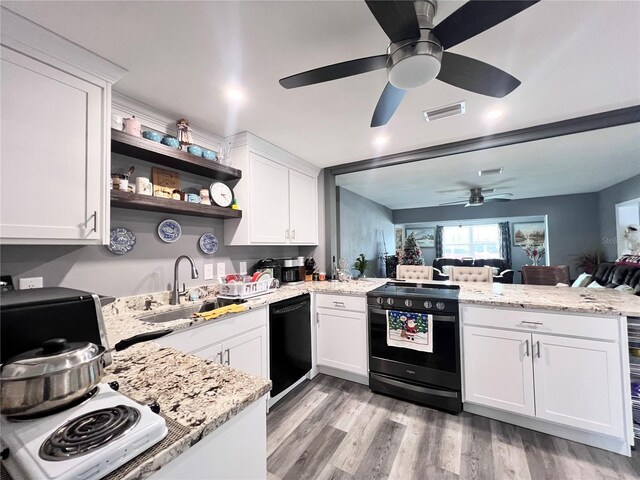 kitchen featuring black appliances, kitchen peninsula, white cabinetry, and sink