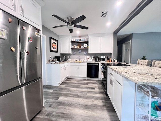 kitchen featuring electric range, dishwasher, stainless steel fridge, a kitchen bar, and white cabinets