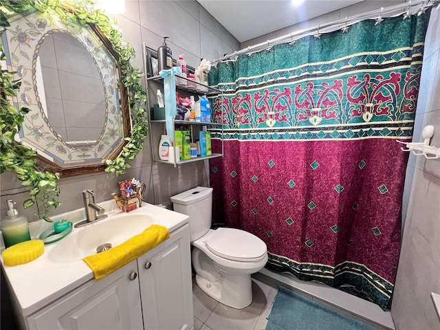 bathroom featuring vanity, a shower with curtain, tile patterned flooring, toilet, and tile walls