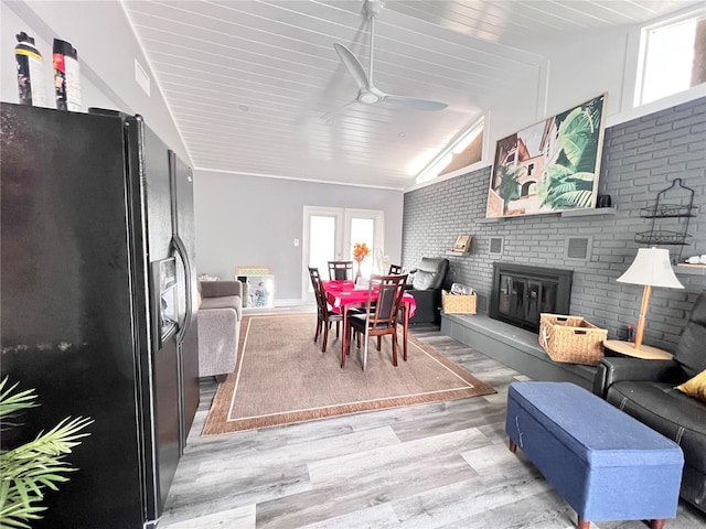 living room with ceiling fan, brick wall, light hardwood / wood-style floors, lofted ceiling, and wood ceiling