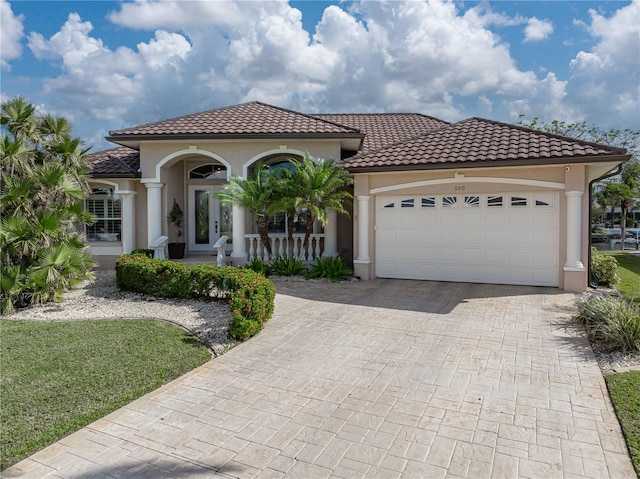 mediterranean / spanish house with covered porch and a garage