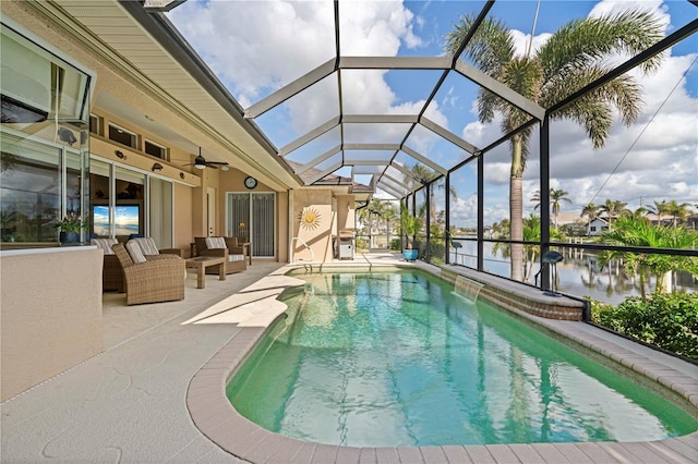 view of pool with a patio, a water view, glass enclosure, and ceiling fan