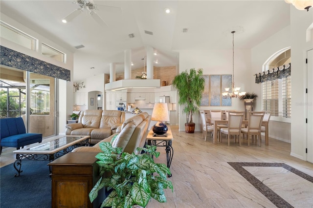 living room featuring ceiling fan with notable chandelier and high vaulted ceiling