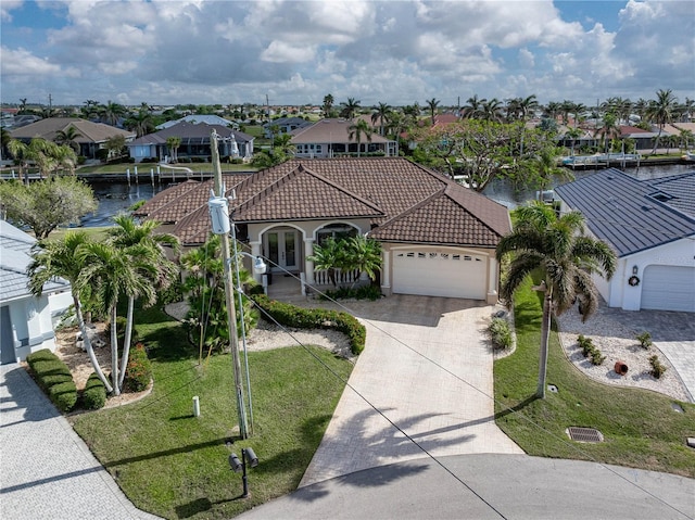 view of front of home featuring a water view, a garage, and a front lawn