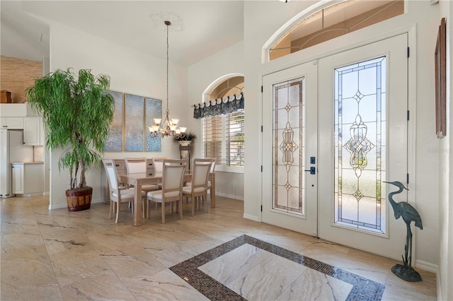 entryway featuring french doors, lofted ceiling, and a notable chandelier