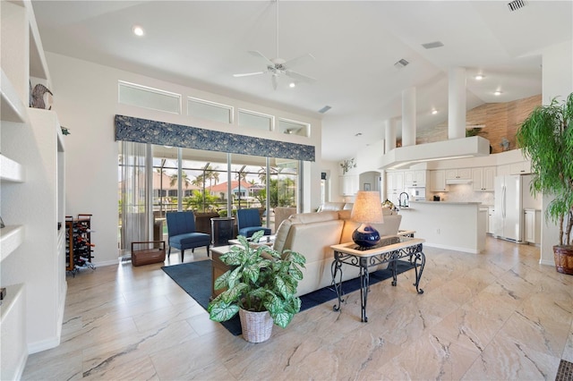 living room with ceiling fan and high vaulted ceiling