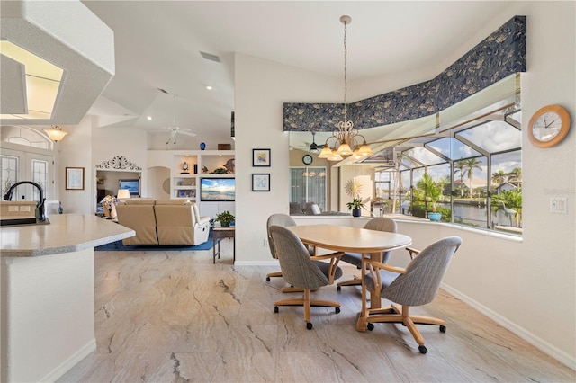 dining area with ceiling fan with notable chandelier, vaulted ceiling, and sink