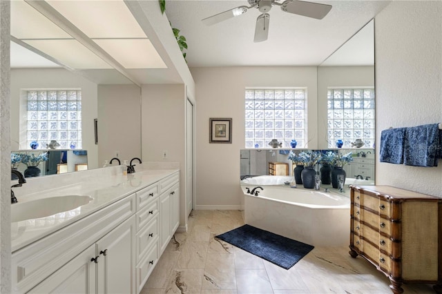 bathroom with vanity, ceiling fan, and a tub