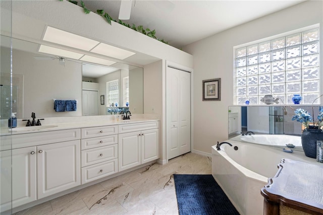 bathroom with vanity, ceiling fan, and a tub to relax in