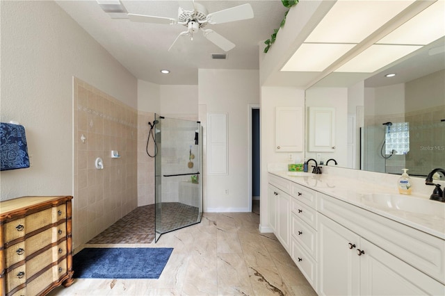 bathroom with a tile shower, vanity, and ceiling fan