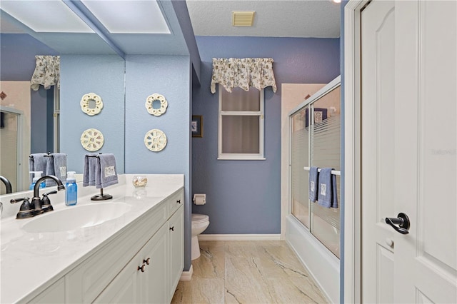 full bathroom featuring combined bath / shower with glass door, a textured ceiling, vanity, and toilet