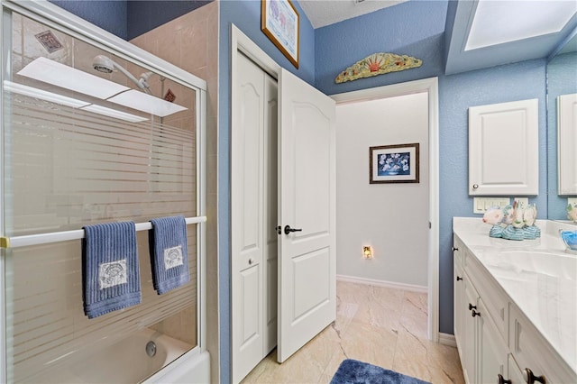 bathroom with vanity and bath / shower combo with glass door