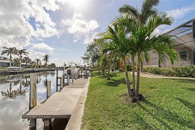 view of dock with a yard, a water view, and a lanai