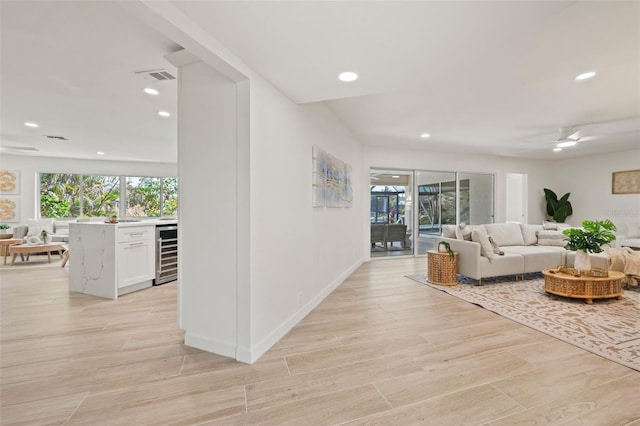 living room with ceiling fan and beverage cooler