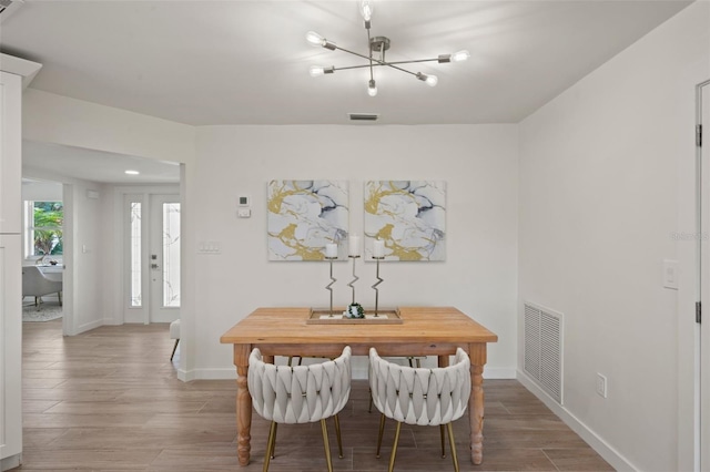 dining space featuring hardwood / wood-style floors and a notable chandelier