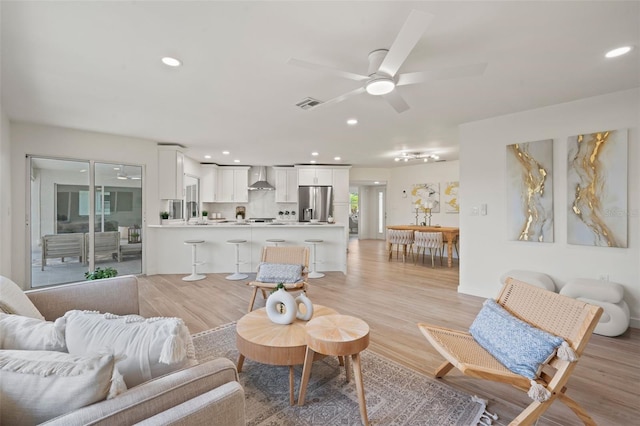 living room with ceiling fan and light wood-type flooring