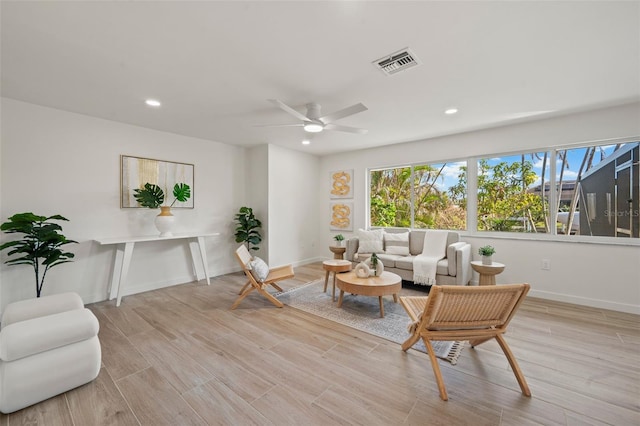 living room with light hardwood / wood-style floors and ceiling fan