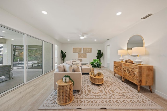 living room featuring ceiling fan and light hardwood / wood-style floors