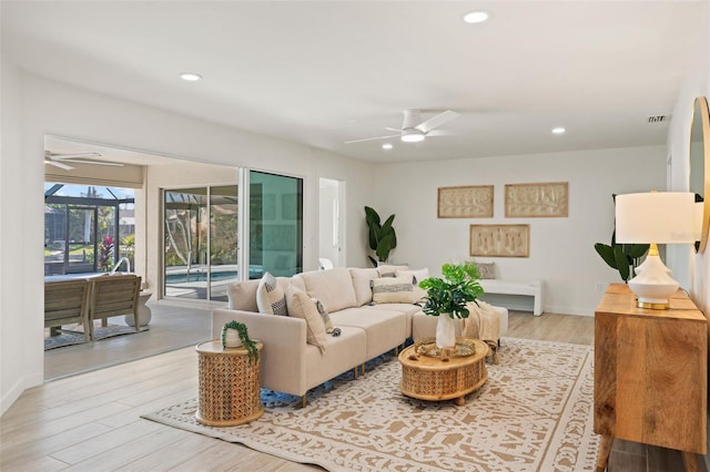 living room featuring light hardwood / wood-style flooring and ceiling fan