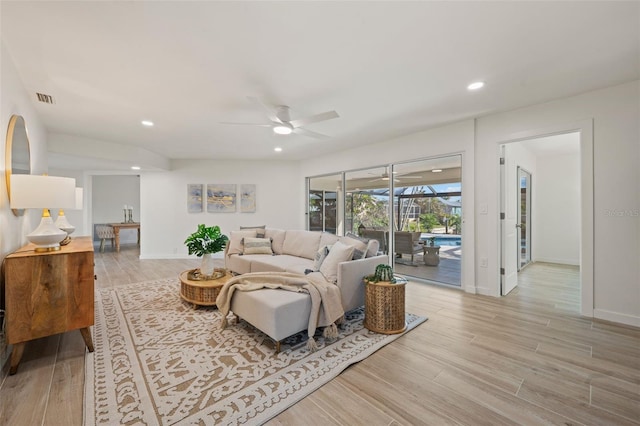 living room featuring light hardwood / wood-style flooring and ceiling fan