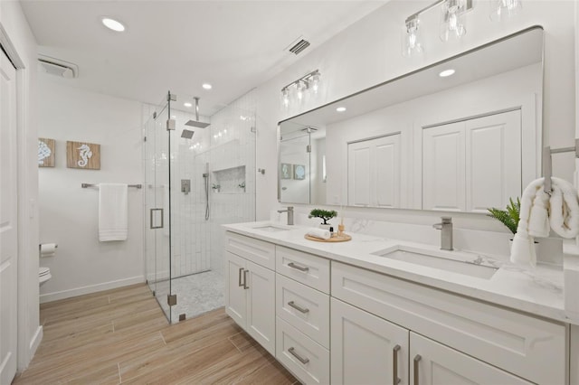 bathroom with toilet, walk in shower, and vanity