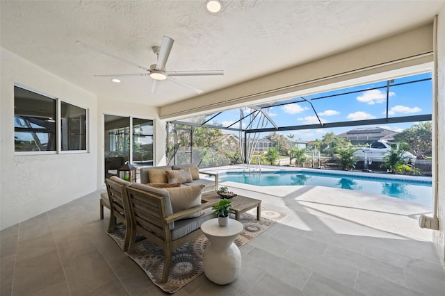 view of pool featuring a lanai, a patio area, an outdoor hangout area, and ceiling fan