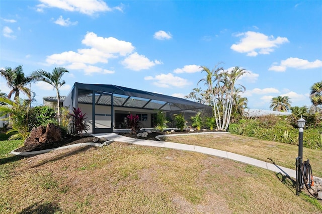 back of house with a lanai and a yard