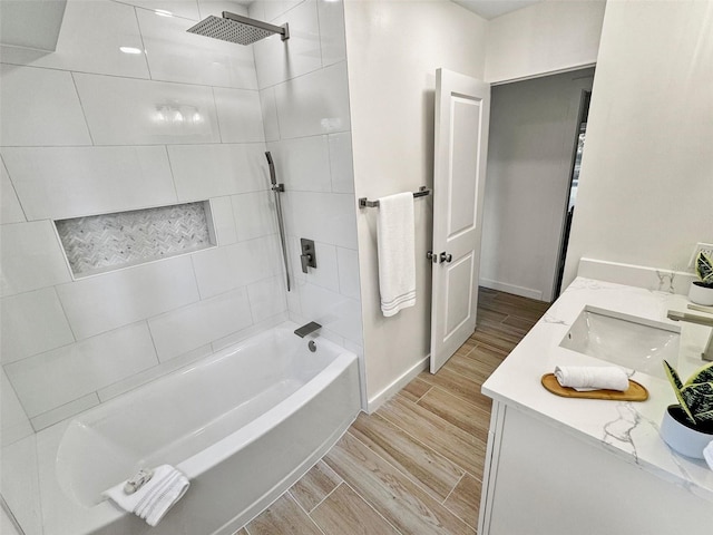 bathroom featuring vanity and tiled shower / bath