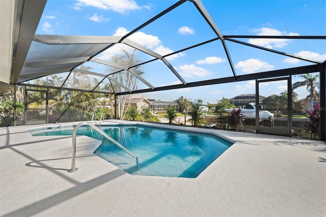 view of pool with glass enclosure and a patio area