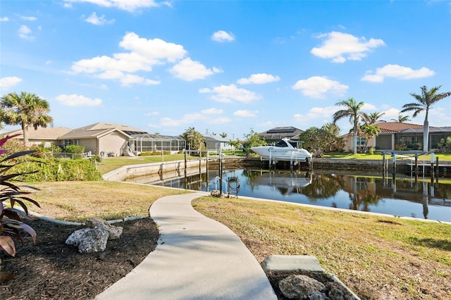 view of community featuring a yard, a dock, and a water view